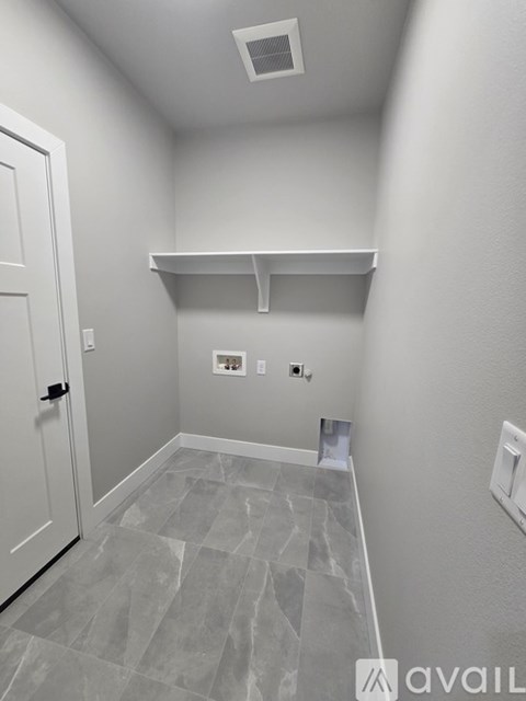 A small, empty room with a door and a shelf.