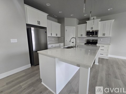 A modern kitchen with white cabinets and a large island.