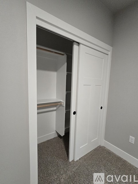 A white door is open to a small, empty room with a window seat.