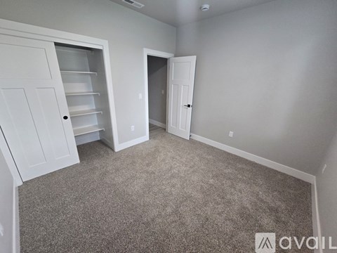 A carpeted room with two white doors and one open.