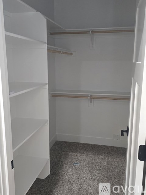 A white closet with shelves and a door.
