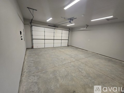 A large empty room with a white wall and a grey floor.