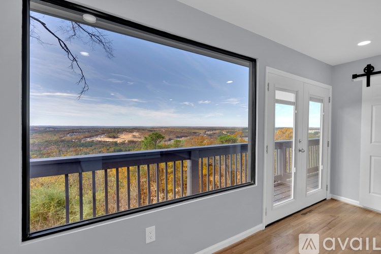 A room with a large window overlooking a landscape.