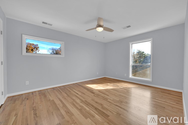 A room with wooden flooring and a ceiling fan.