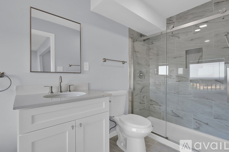 A bathroom with a white toilet, sink, and mirror.