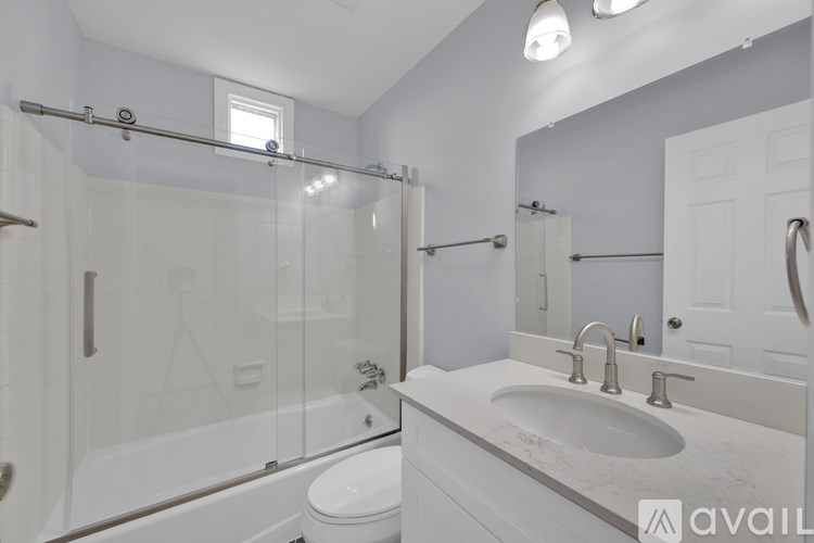 A bathroom with a white toilet, sink, and bathtub.
