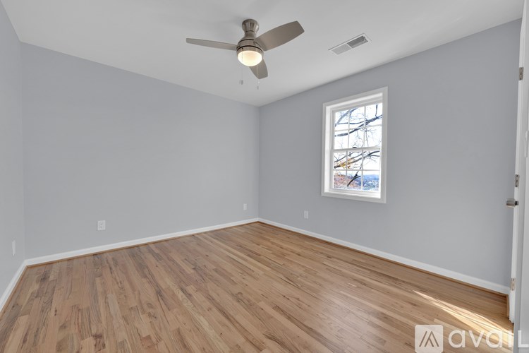 A room with wooden flooring and a ceiling fan.