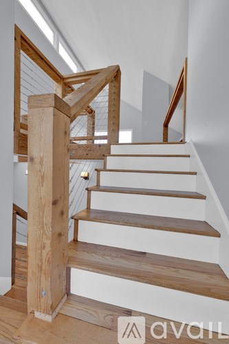 A wooden staircase with a glass balustrade.