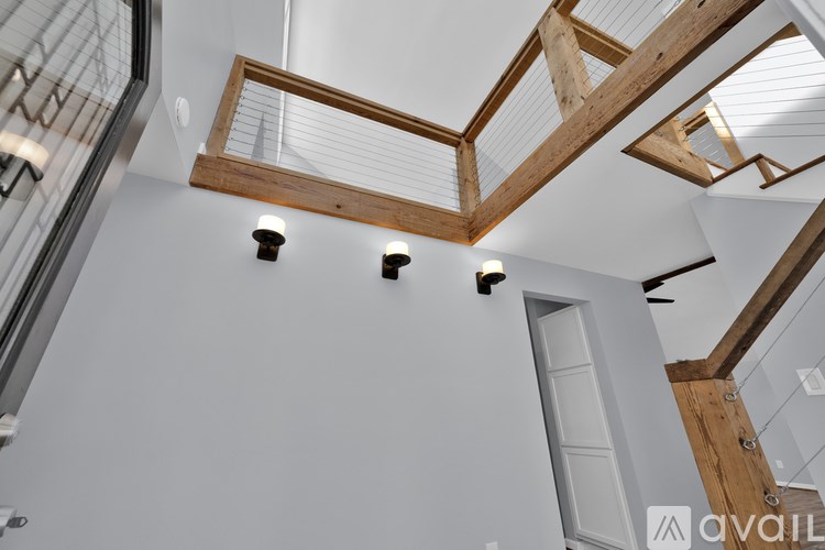 A white interior with wooden beams and lights.