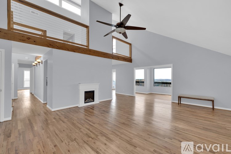 A spacious room with wooden floors and a fireplace.
