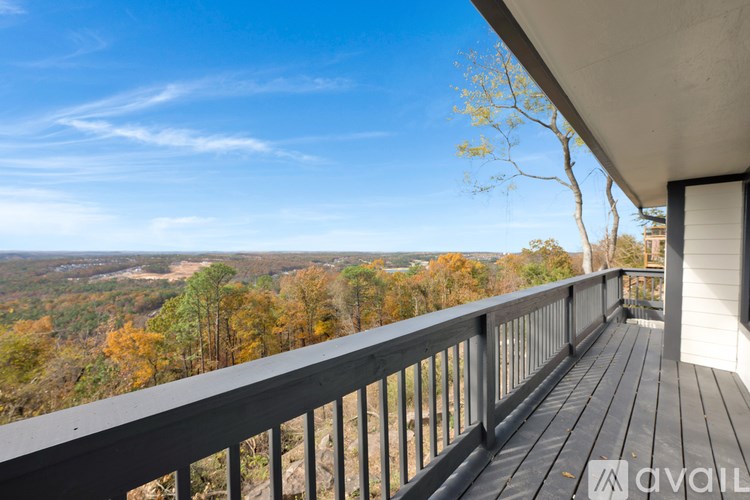A balcony with a view of a forest in autumn.