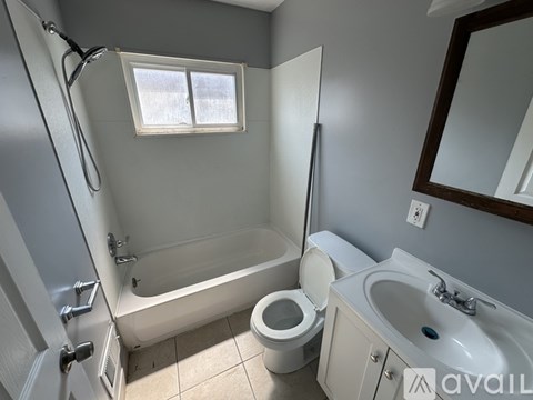 A bathroom with a toilet, sink, and bathtub.