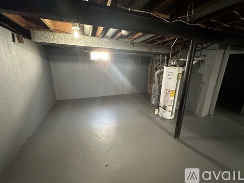A room with a white wall and a ceiling with wooden beams.