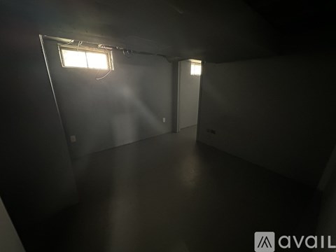 A dark room with a light on the left side.