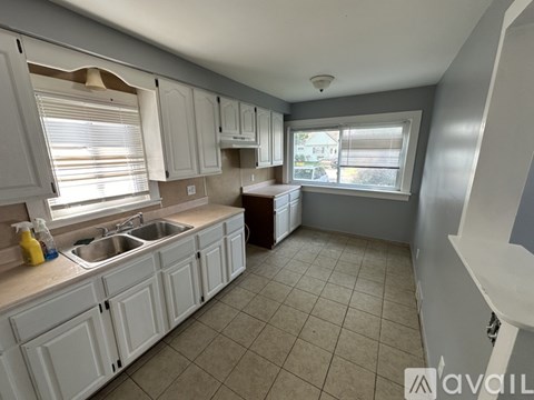 A kitchen with white cabinets and a sink.