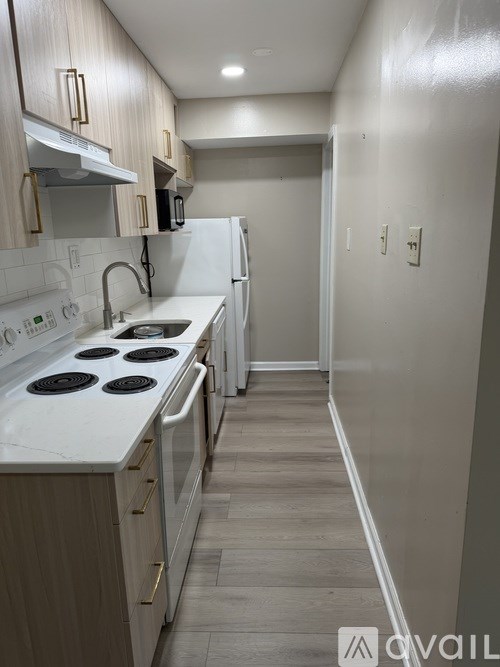 A kitchen with white appliances and wooden cabinets.