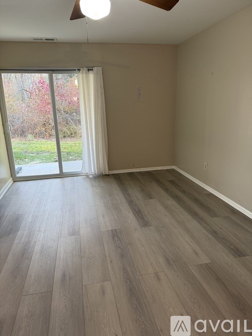 A room with a sliding glass door leading to a garden.