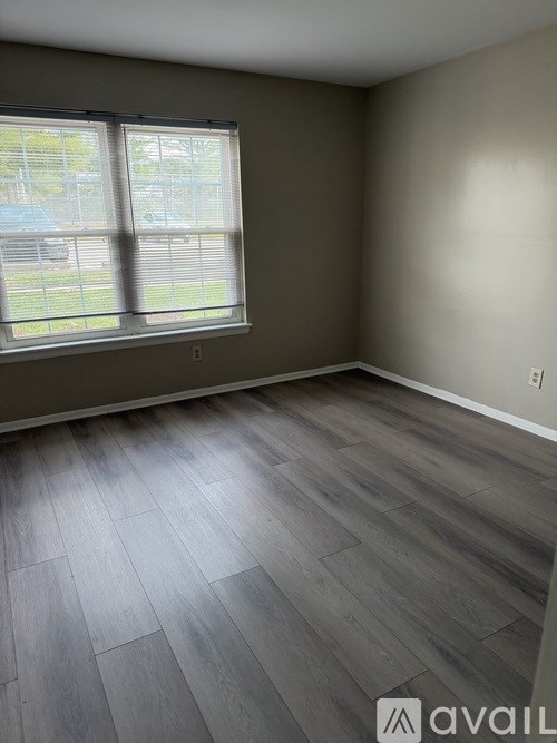 A room with a large window and wooden flooring.