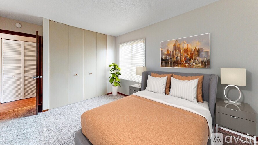 A bedroom with a bed, nightstand, and a painting on the wall.