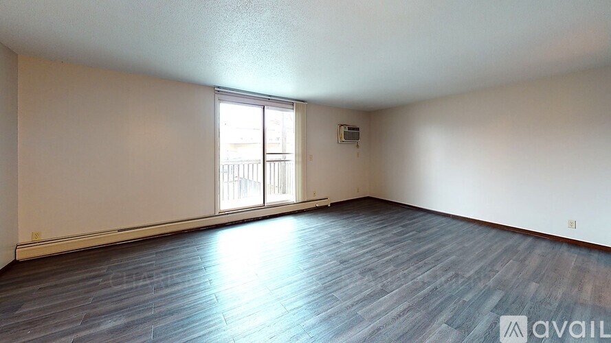 A room with wooden flooring and a window letting in light.