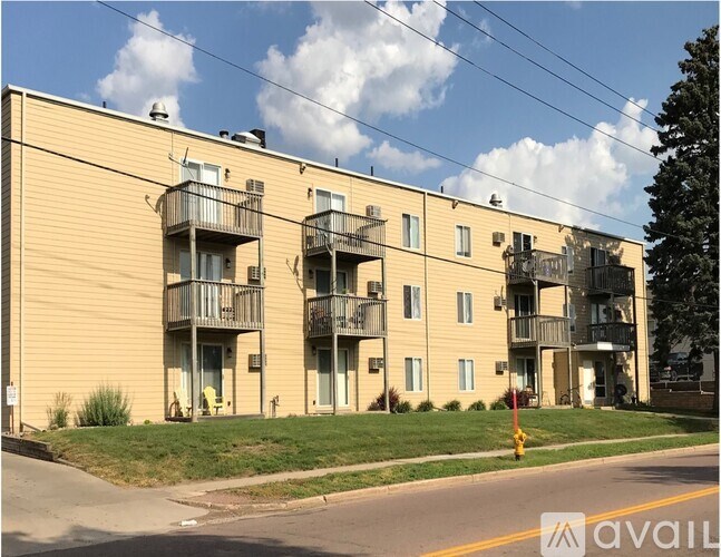 A building with balconies and a sign that says "available" in front of it.