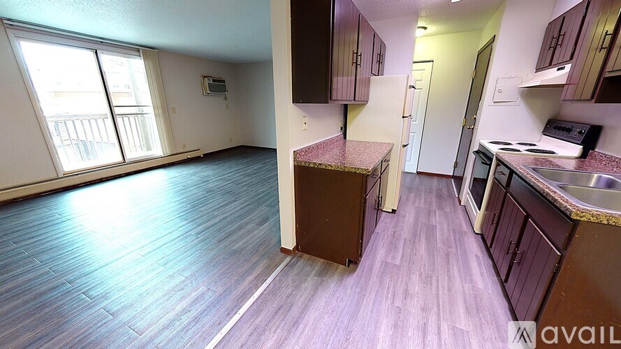 A kitchen with purple flooring and wooden cabinets.