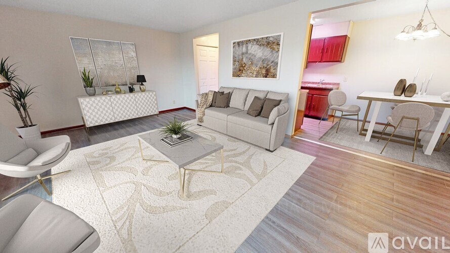 A living room with a white sofa, a grey armchair, and a coffee table with a plant on it.