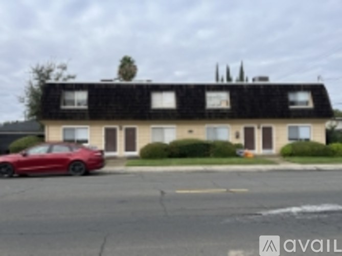 A red car is parked in front of a house.