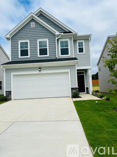 A two-story house with a garage and a driveway.