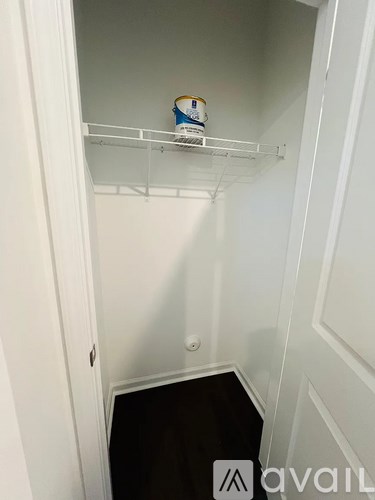 A white pantry with a shelf and a container on it.
