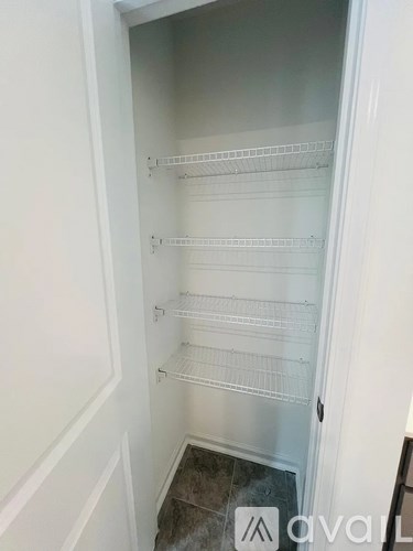 A white pantry with shelves and a door.