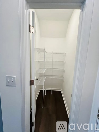 A white hallway with a black door and a white wall.