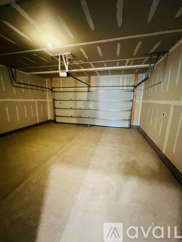 A spacious garage with a closed white door and a light on the ceiling.