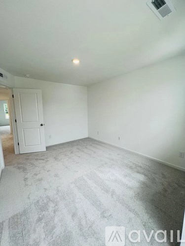 A room with a carpeted floor and a door.