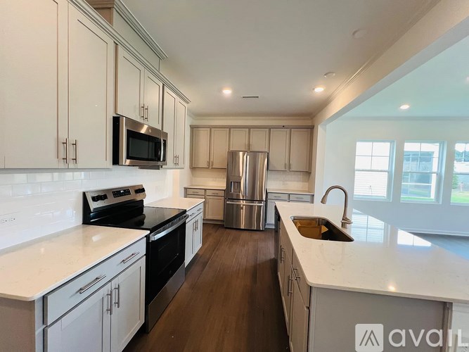 A kitchen with white cabinets and a stainless steel refrigerator.
