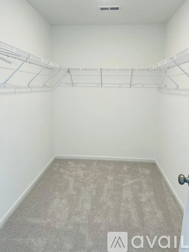 Empty room with a carpeted floor and a door on the right side.