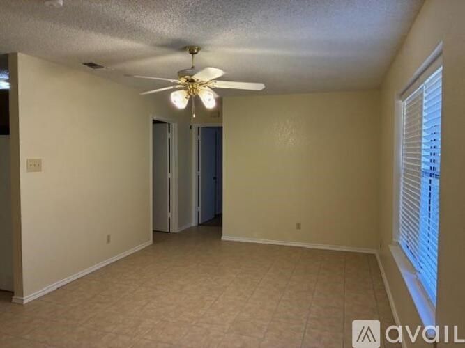 A room with a ceiling fan and carpeted floor.
