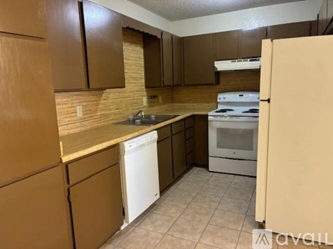 A kitchen with brown cabinets and a white dishwasher.
