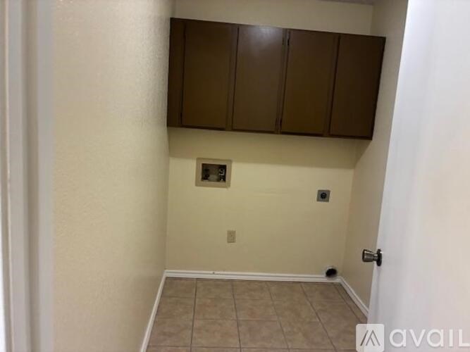 A room with brown cabinets and a tiled floor.