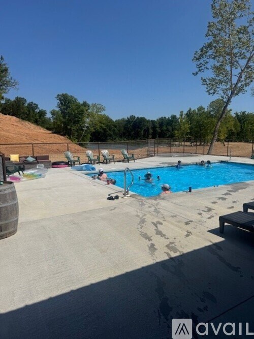 A sunny day at the pool with people swimming and relaxing.