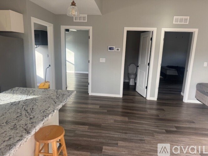 A kitchen with a marble countertop and a wooden stool.