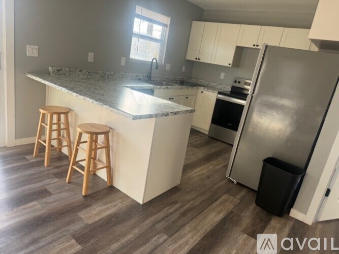 A kitchen with a marble countertop and wooden stools.