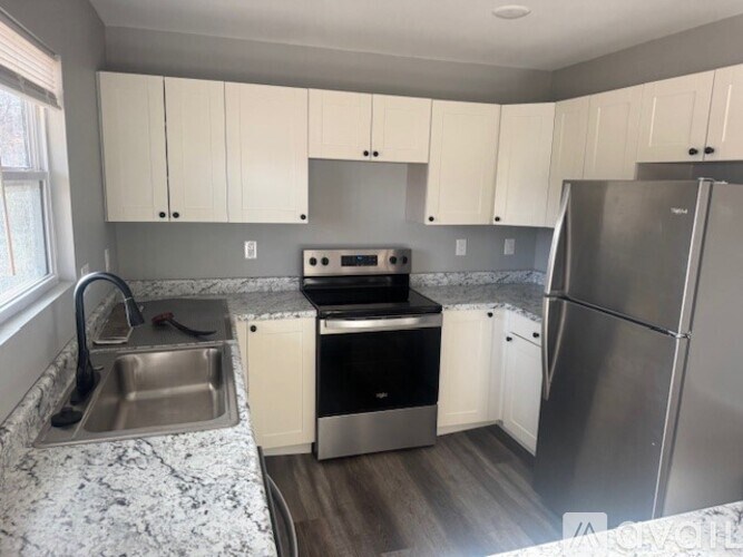 A kitchen with a stove, sink, and refrigerator.