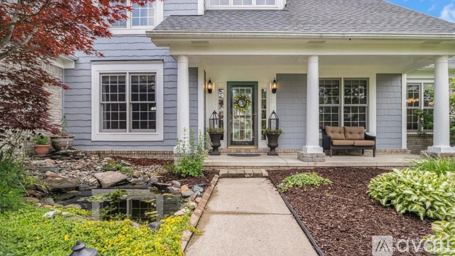 A house with a grey front and a small garden.