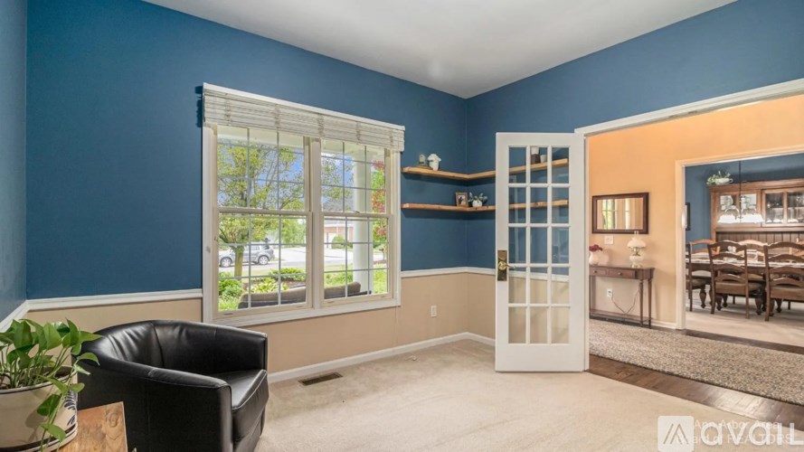 A room with blue walls and a black leather chair.