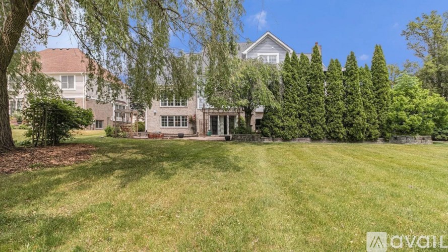 A house with a lawn and trees in front of it.