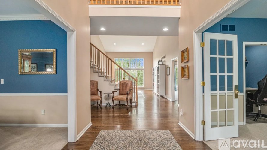 A hallway with a blue wall and a mirror.
