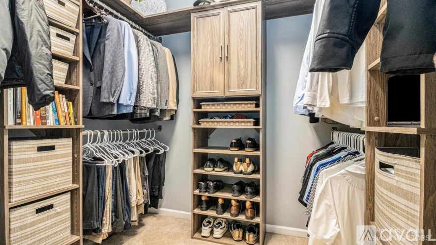 A well-organized walk-in closet with clothes and shoes neatly arranged.