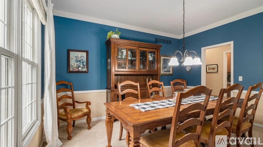 A dining room with a wooden table and chairs.