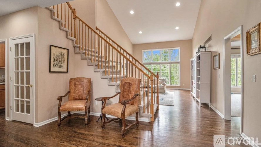 A living room with a staircase and two chairs.